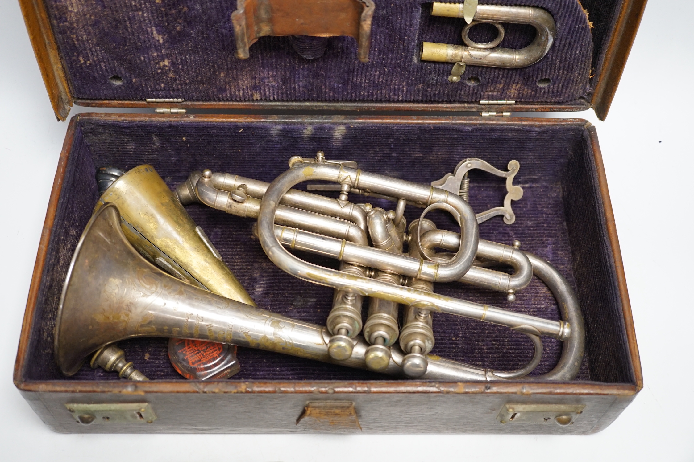 A cased Hawkes & Son cornet, bell engraved with ‘Excelsior Soncrous Class A’ and an ‘American Standard High Grade’ trumpet, with a brass mute and three mouthpieces